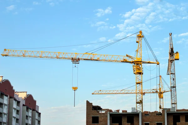 Construcción del nuevo edificio de ladrillo mediante la grúa elevadora —  Fotos de Stock