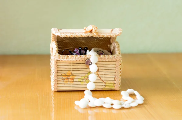 Various women's beautiful jewelry in a wicker box — Stock Photo, Image