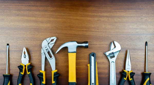 Různé Nástroje Pro Domácí Práce Jsou Zobrazeny Řadě Pozadí Hnědé — Stock fotografie