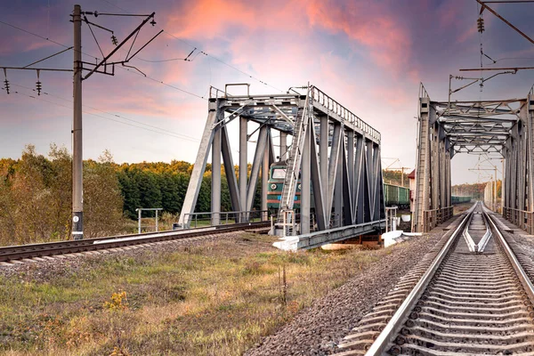 Grüne Lokomotive Mit Güterwagen Fährt Über Eine Metallbrücke Gegen Den — Stockfoto