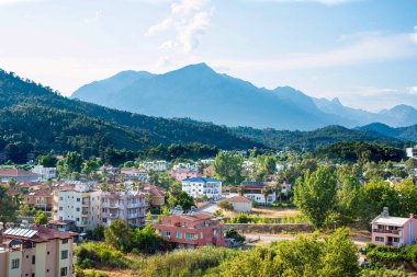 Türkiye 'de tatil köyü, yaz aylarında yeşil ağaçlı yüksek dağların arka planında