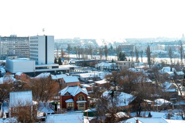 Kışın beyaz karla kaplı evleri olan şehir caddesi.