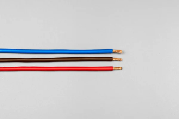 Kırmızı Mavi Kahverengi Izolasyonlu Bakır Kablo Mat Gri Arka Planda — Stok fotoğraf