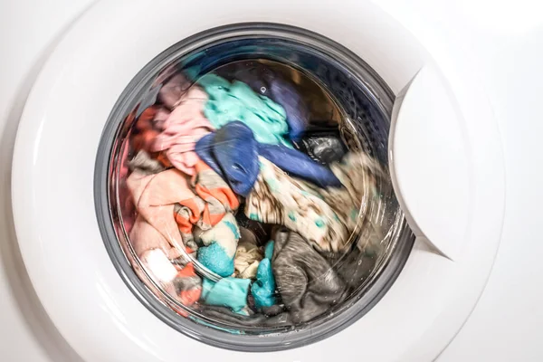 Çamaşırları çamaşır makinesinin önünde yıkama süreci.