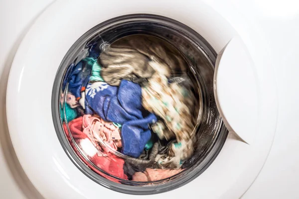 Çamaşırları çamaşır makinesinin önünde yıkama süreci.