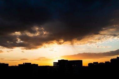 Gün batımında şehir evlerinin silueti. Arka planda güzel gökyüzü ve bulutlarla.
