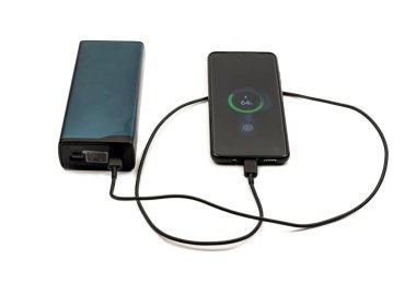 Beyaz arka planda bir güç bankasıyla bir cep telefonunu şarj etme işlemi