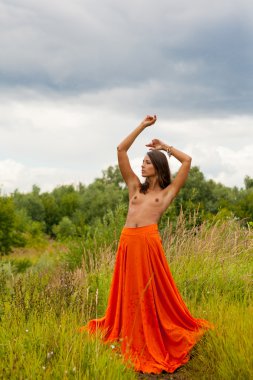 yağmur altında bir alanda poz kırmızı etekli beyaz üstsüz kız