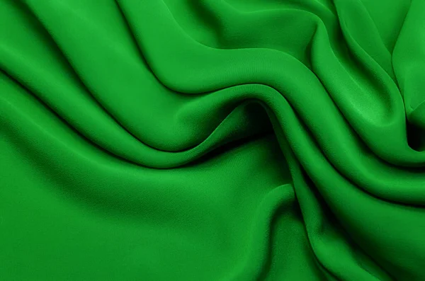 Texture, background, pattern. Texture of green silk or cotton or wool fabric. Beautiful pattern of fabric.