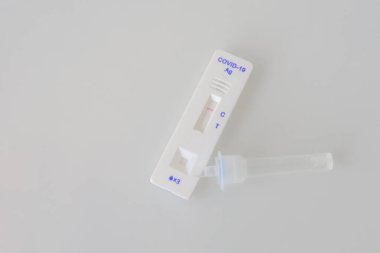 Gri arkaplanda kapalı bir covid-19 antijen PCR ekspres testi. Test negatif sonuç verdi.