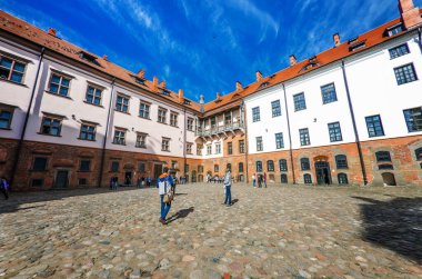 MIR, BELARUS - 13 Haziran 2014 'te Beyaz Rusya' nın Grodno Bölgesi 'ndeki MIR Kalesi yakınlarında kimliği belirsiz kişiler yürüdü. Kale bir savunma kalesidir. XVI-XVII.