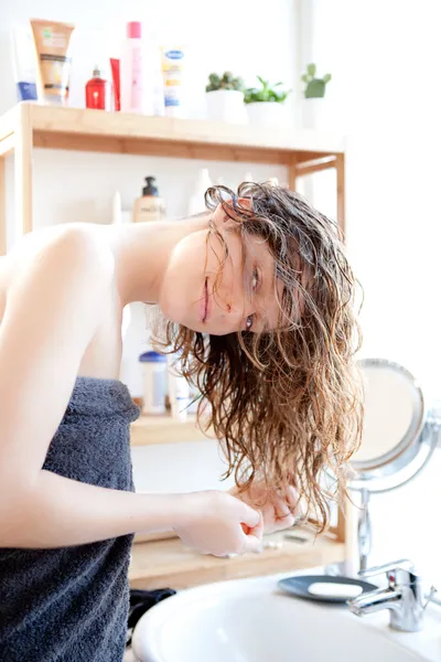 Giovane ragazza prendersi cura dei suoi capelli in un bagno — Foto Stock