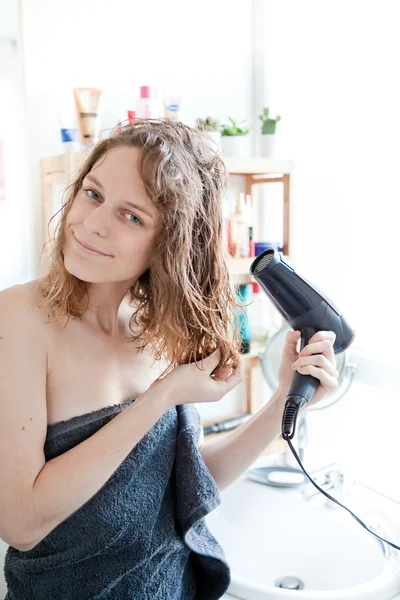 Junges Mädchen kümmert sich im Badezimmer um ihre Haare — Stockfoto