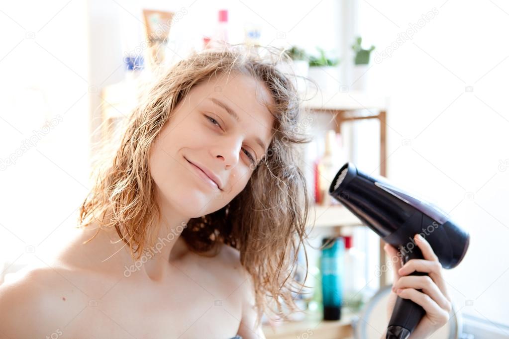 Young girl taking care of her hairs in a bathroom