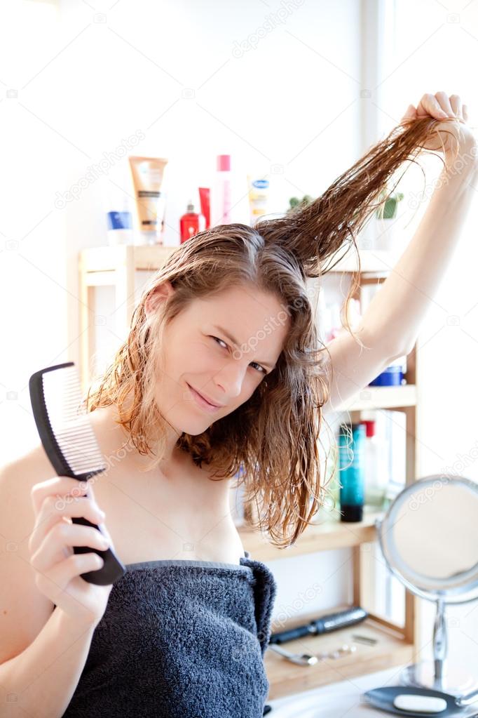 Young girl taking care of her hairs in a bathroom