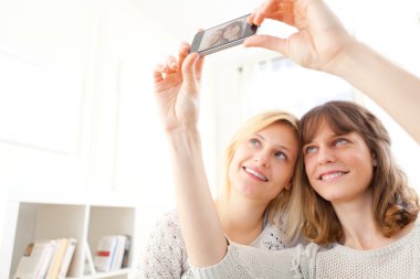 Kızlar selfie fotoğrafını smartphone ile Divan