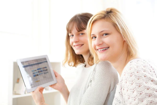 Girls choosing their holidays destination on tablet — Stock Photo, Image