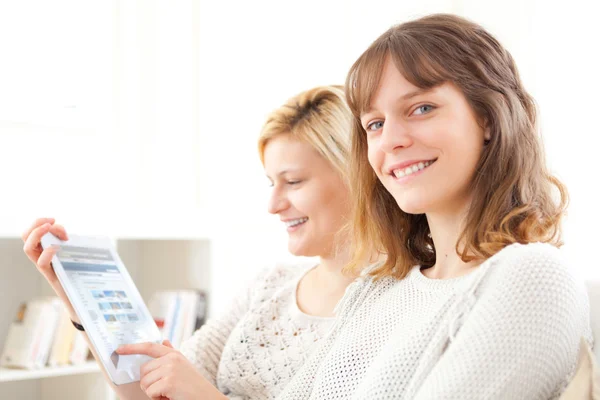 Girls choosing their holidays destination on tablet — Stock Photo, Image