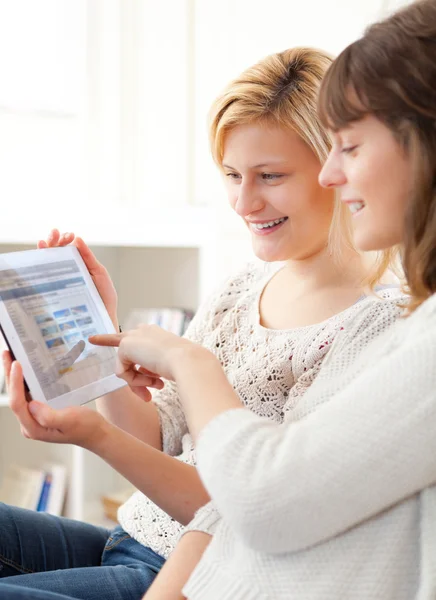 Girls choosing their holidays destination on tablet — Stock Photo, Image