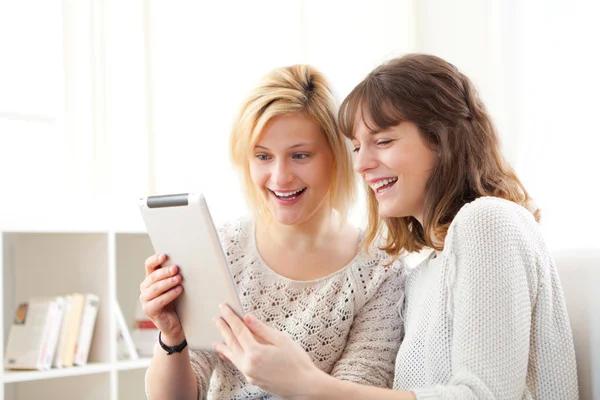 Meisjes lachen en kijken naar grappige dingen op Tablet PC — Stockfoto