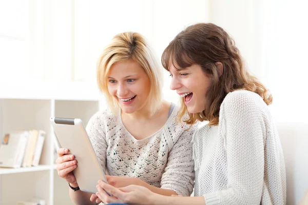 Meisjes lachen en kijken naar grappige dingen op Tablet PC — Stockfoto