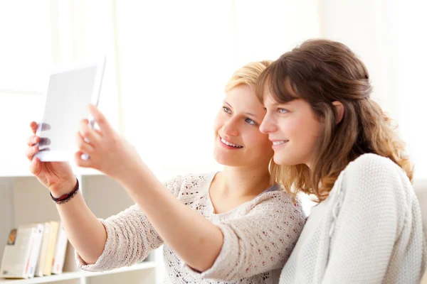 Girls on sofa taking selfie picture with tablet — Stock Photo, Image