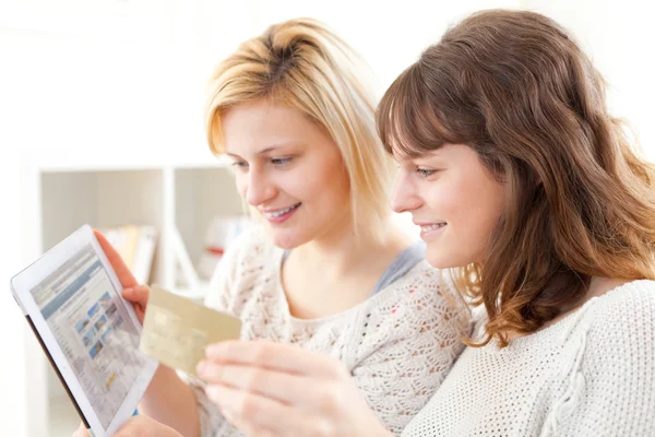 Девушки платят кредитной картой на планшете — стоковое фото