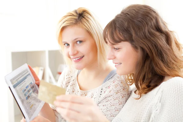 Meninas que pagam com cartão de crédito em seu tablet — Fotografia de Stock