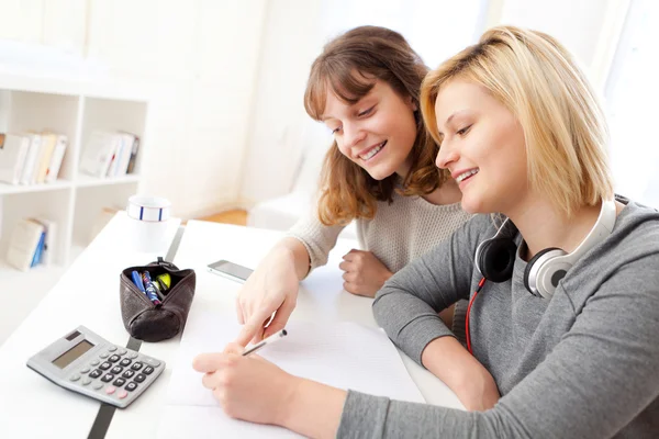 Unga lärare hjälpa en student under hennes läxor — Stockfoto