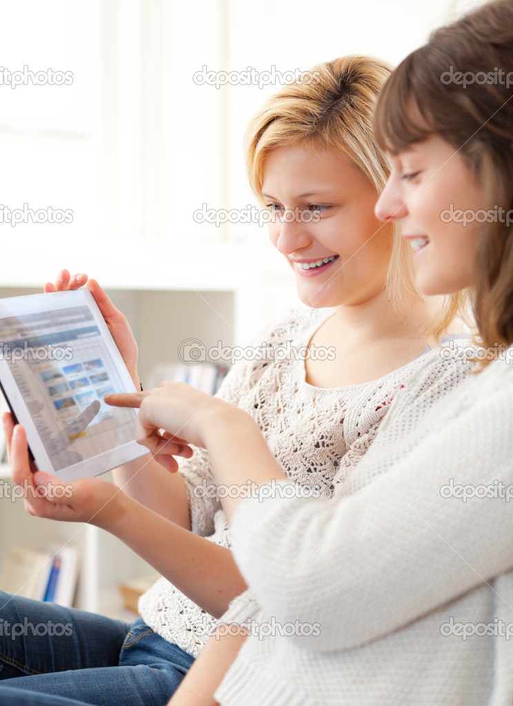 Girls choosing their holidays destination on tablet