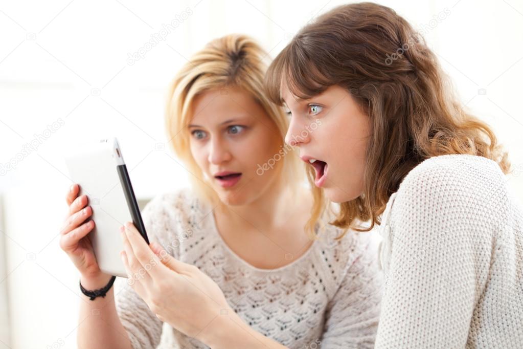 Girls learning important news reading on tablet 