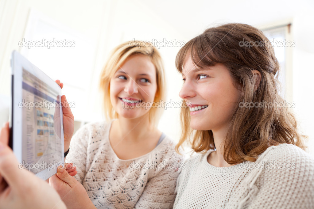 Girls choosing their holidays destination on tablet