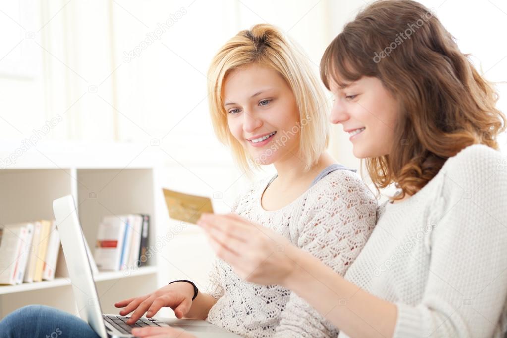 Girls paying with credit card on their computer