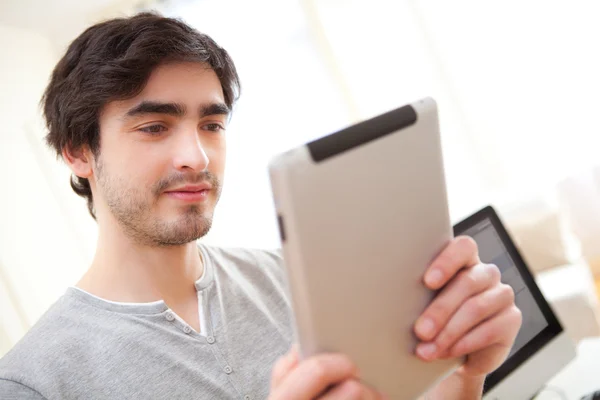 Jeune homme utilisant une tablette au bureau — Photo