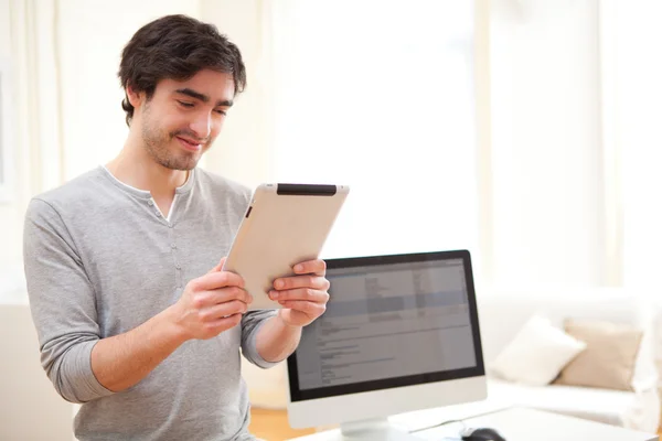 Молодой человек использует планшет в офисе — стоковое фото