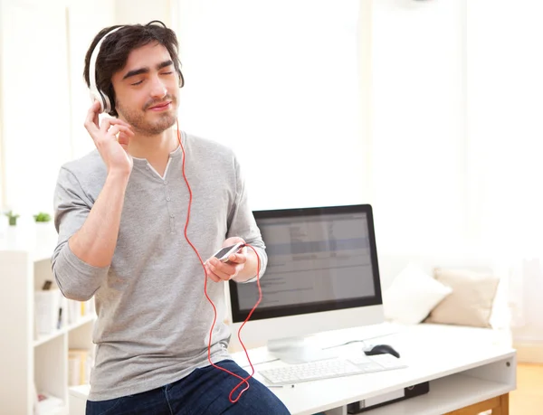 Entspannter junger Mann hört Musik im Büro — Stockfoto