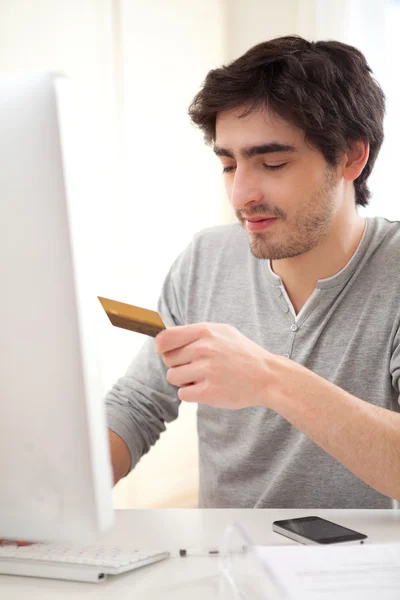 Entspannter junger Mann bezahlt online mit Kreditkarte — Stockfoto