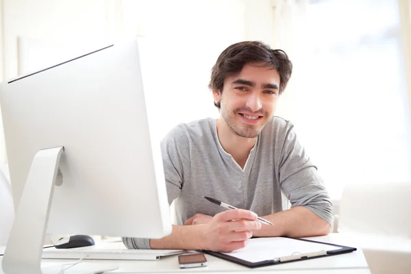 Retrato de un joven relajado escribiendo en la oficina — Foto de Stock