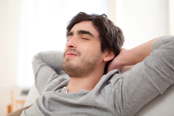 Jeune homme relaxant pendant une pause dans le canapé — Photo