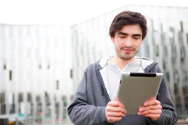 Portrait d'un jeune homme détendu utilisant une tablette dans la rue — Photo