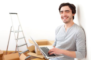 yakışıklı delikanlı dizüstü kullanarak onun yeni daire