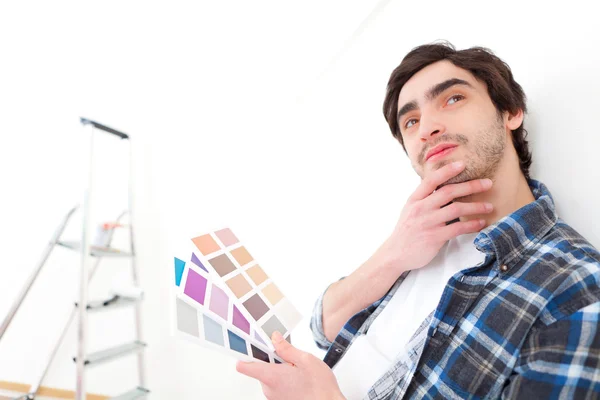 Atrakcyjny młody człowiek wybiera kolor jego mieszkania — Zdjęcie stockowe