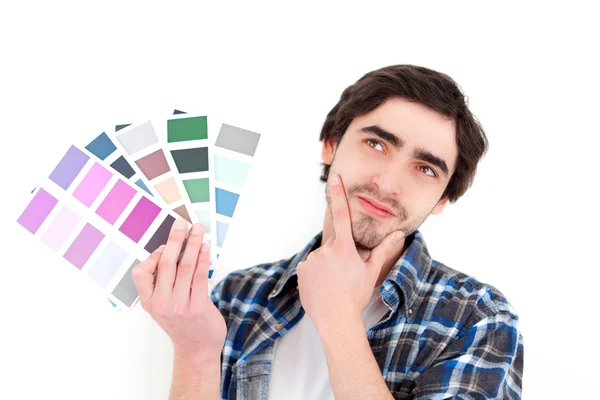 Attractive young man choosing color of his flat — Stock Photo, Image