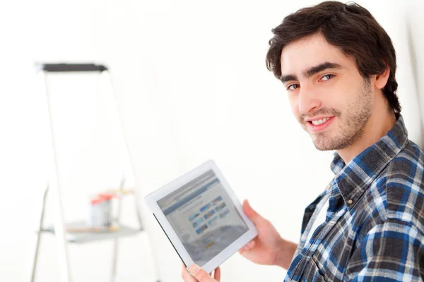 Attraktiver junger Mann mit Tablet in seiner neuen Wohnung — Stockfoto