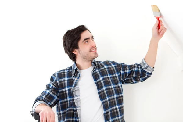 Attraktiver junger Mann beim Bemalen einer Wand in seiner neuen Wohnung — Stockfoto