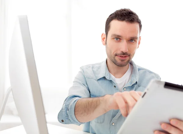 Jeune homme détendu utilisant une tablette à la maison — Photo