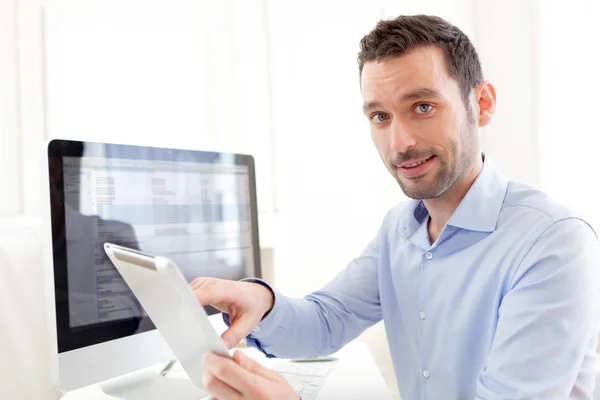 Young business man working at home on his tablet — Stock Photo, Image