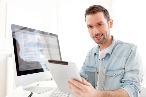Young relaxed man using tablet at home — Stock Photo, Image