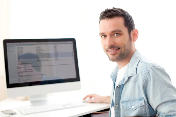 Young relaxed man using computer — Stock Photo, Image