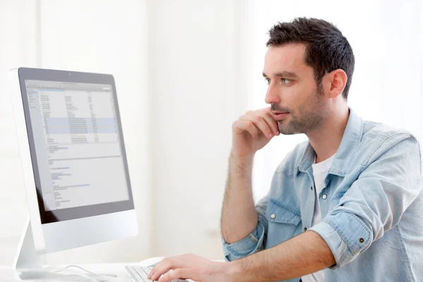 Joven hombre relajado utilizando la computadora — Foto de Stock